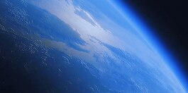 Lineup of battery lawn mowers from left to right HRN, HRX, HRX, HRC. Background is grass images from top fading into plain blue.